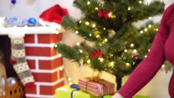 Baby en zwangere moeder hangen rode bal speelgoed aan kerstboom. Gelukkige kindertijd concept. kind en moeder versieren boom met kerstballen. klein kind en een ouder spelen bij kerstboom. — Stockvideo