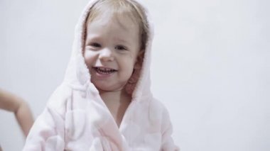 Banyo yaptıktan sonra ıslak saçlı, beyaz arka planda iki çocuk. Beyaz bir yatakta duştan sonra kız ve erkek. Bornozlu kız ve erkek kardeşler yatmadan önce oynarlar. Çocuklar, İrlandalı ikizler