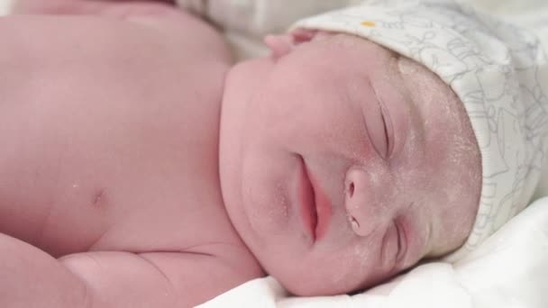 原初のグリースで生まれた泣いている新生児の終わりの肖像画は、目を開き、舌を突き出します。安定した射撃ではなく、目を閉じて新生児の顔. — ストック動画