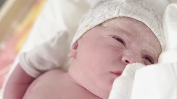 Close-up portret van een pasgeborene in oervet dat zijn ogen opent. Het gezicht van een pasgeborene met open ogen van dichtbij, niet gestabiliseerd schieten. Baby pasgeboren na de geboorte huilen eerste minuten van het leven. — Stockvideo