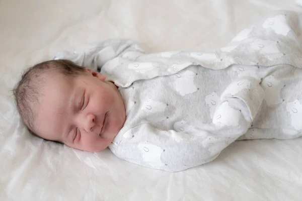 一个新生婴儿在生命的头几分钟里的画像，他在梦中微笑。新生儿在白皙的背景下，在梦中微笑. — 图库照片