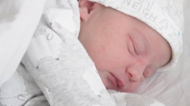 Yaşamın ilk günlerinde titreyen, gülümseyen ve bir rüyada esneyen yeni doğmuş bir bebeğin yüzünü yakından çek. Yeni doğmuş bir bebek bir rüyada yüzünü buruşturur. Hayatın ilk dakikalarında yeni doğmuş bir bebek.