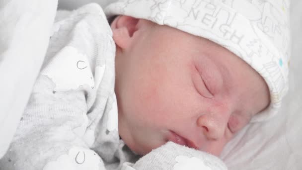 Großaufnahme eines neugeborenen Babys, das in den ersten Lebenstagen aufwacht und die Augen öffnet. Ein Neugeborenes wacht auf und öffnet die Augen. — Stockvideo