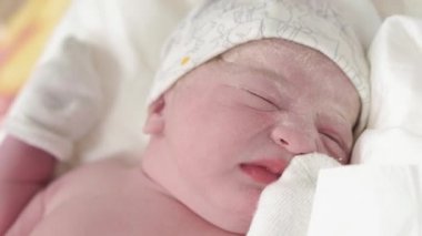 İlkel bir yağda ağlayan bir bebeğin portresini yakından çek. Gözleri açık, yeni doğmuş bir bebeğin yüzü, dengeli bir atış değil. Bebek doğduktan sonra ağlar, hayatın ilk dakikalarında..