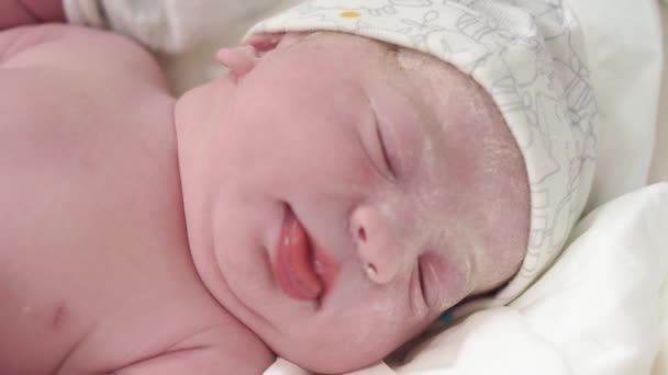 Portret płaczącego noworodka w pierwotnym tłuszczu, który otwiera oczy i wystaje z języka. Twarz noworodka z otwartymi oczami z bliska, nieustabilizowana strzelanina. — Wideo stockowe