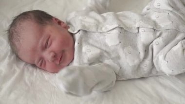 Sabit plana göre, yeni doğanlar için camdan bir yatakta yeni doğmuş bir bebek uyanır ve hayatın ilk günlerinde yüzünü buruşturur. Yeni doğmuş bir bebek bir rüyada yüzünü buruşturur. Hayatın ilk dakikalarında yenidoğan