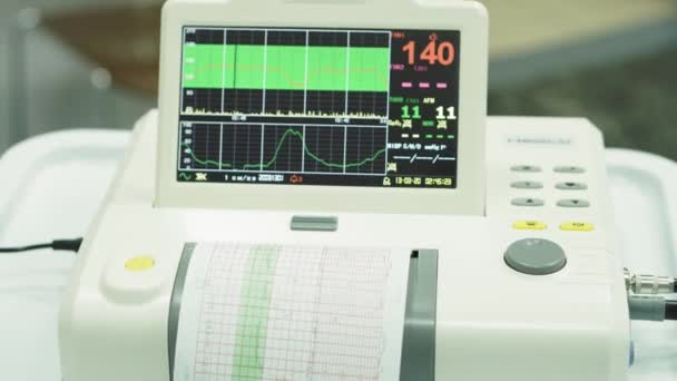 EKG monitor Cardiógrafo. Visualización del cardiógrafo durante la medición de los latidos cardíacos del bebé en el útero. Medición de los latidos cardíacos del bebé en el útero mediante un cardiógrafo antes del nacimiento . — Vídeos de Stock