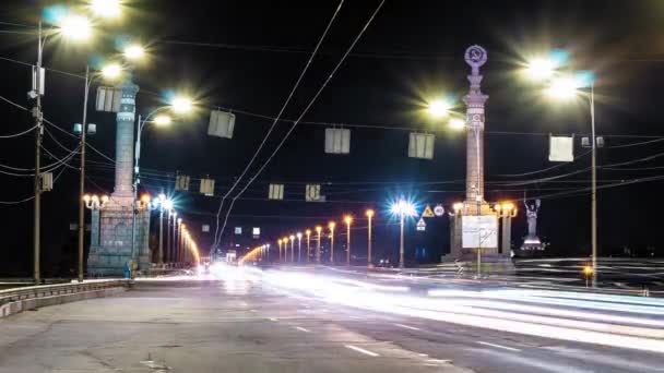 タイムラプスナイトロード長時間露光。車のぼやけたヘッドライトとキエフの夜の経過。車のぼやけたヘッドライトを持つ長い橋を介して夜の道路。キリル文字での交通標識. — ストック動画