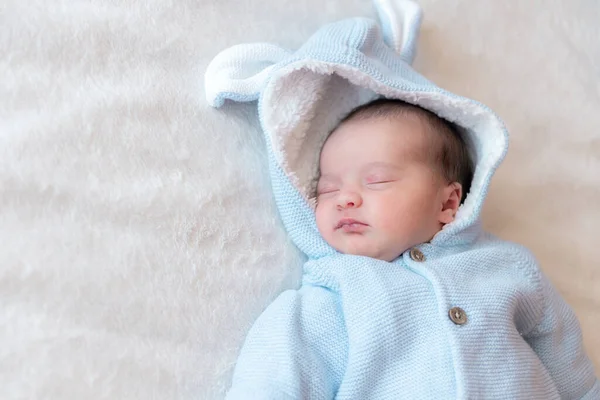 新生儿特写，放在文字上。刚出生的宝宝穿着蓝色的衬衫躺在床上睡在白色的背景图片上。米色背景下睡着的新生儿的肖像. — 图库照片