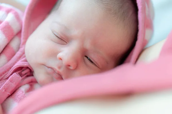 Nouveau-né dans les bras de maman. Portrait d'un nouveau-né. Gros plan du visage du nouveau-né avec les yeux ouverts. Bébé regarde de près dans la lentille. Nouveau-né en chemisier rose . — Photo