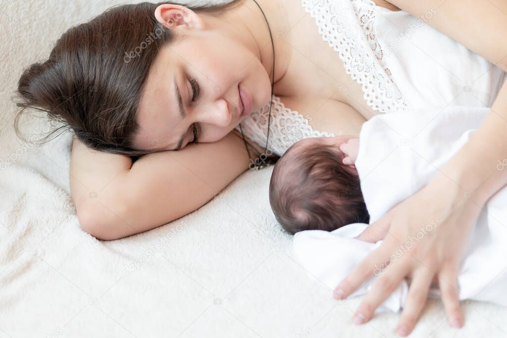 motherhood, infancy, childhood, family, care, medicine, sleep, health, maternity concept - portrait of mom with newborn baby wrapped in diaper on white background, place for text, close-up, soft focus