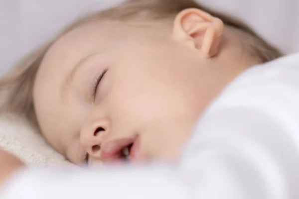 Jeugd, slaap, rust, familie, lifestyle concept - close-up portret van een schattig jongetje van 2 jaar oud in een wit lichaam slapen op een beige bed 's middags met mond open boven- en zijaanzicht. — Stockfoto