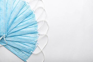 Birkaç tıbbi mavi kullan-at koruyucu maske üst üste beyaz arka planda vantilatör şeklinde. Cerrahi giysi ağız ve burnu kapatır. Sağlık, ilaç, covid-19, salgın konsepti..