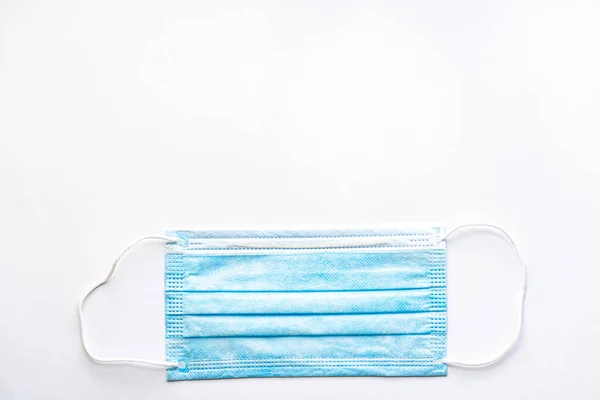 Medical blue disposable protective mask on a white background copy space. A surgical dressing closes the mouth and nose. Healthcare, medicine, covid-19, epidemic concept. — Stock Photo, Image