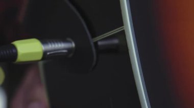 Müzik, yaratıcılık, konser, kendini izole etme konsepti. Akustik gitar radyosu çalan genç adamın yakın çekim elleri. Parmaklar dizgileri fretboard akorlarına basarak ayır.