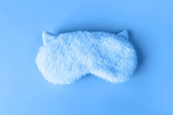 Fluffy fur sleep mask with small ears on paper background. Top view, flatlay. Accessories for girls and young women in Classic Blue colour, close-up, top view. Color of the year 2020 concept — ストック写真