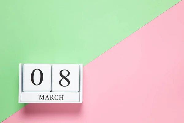 Eeuwige kalender met datum 8 maart op tweekleurige achtergrond roze en groen. Plat gelegd. Bovenaanzicht. International Happy Womens Day viering concept. Horizontaal, close-up, kopieer spase. Voor levering — Stockfoto