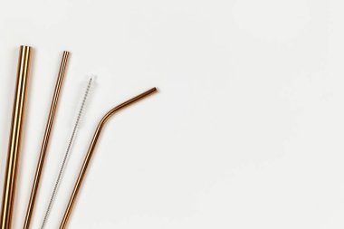 Plastik kullan-at tüplere karşı çevresel metal tüplerden çıkan borular. Tek kullanımlık sofra takımı konseptine alternatif. Beyaz arka plan. Yatay olarak. Uzayı kopyala Düz yat, yakın çekim, üst veiw
