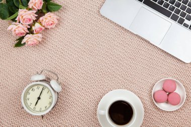 Ev konseptinden esinlendim. Modern kadın çalışma alanı, üst görünüm. Laptop, kahve, pasta, güller, örgü battaniyedeki saat, fotokopi alanı, düz yatak. Serbest İşçi Masası. Nesnelerin çerçevesi. Yatay.