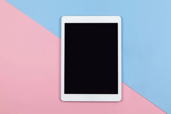 Modern kadın çalışma alanı, üst görünüm. İki renkli arka plan, pembe ve mavi tablet, kopyalama alanı, düz alan. Küçük işletme, evden çalışma, teknolojiyi kullanma, serbest çalışma, boş zaman kavramı. Yatay.