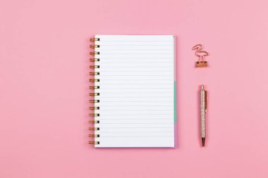 Modern kadın çalışma alanı, üst görünüm. Not defterleri, kalem, arka planda kıskaçlar, kopyalama alanı, düz yatış. Serbest Çalışanlar Masası, Öğrenci. Evden çalışmak, okula dönmek, eğitim kavramı. Yatay.