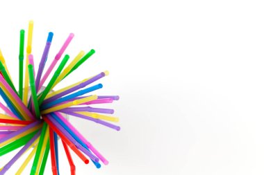 Tek kullanımlık plastik borular, beyaz arka plandaki bardakta içecekler için, kopyalama alanı. Şenlik konsepti, parti, doğum günü. Düz yerde, üst tarafta. Yatay.