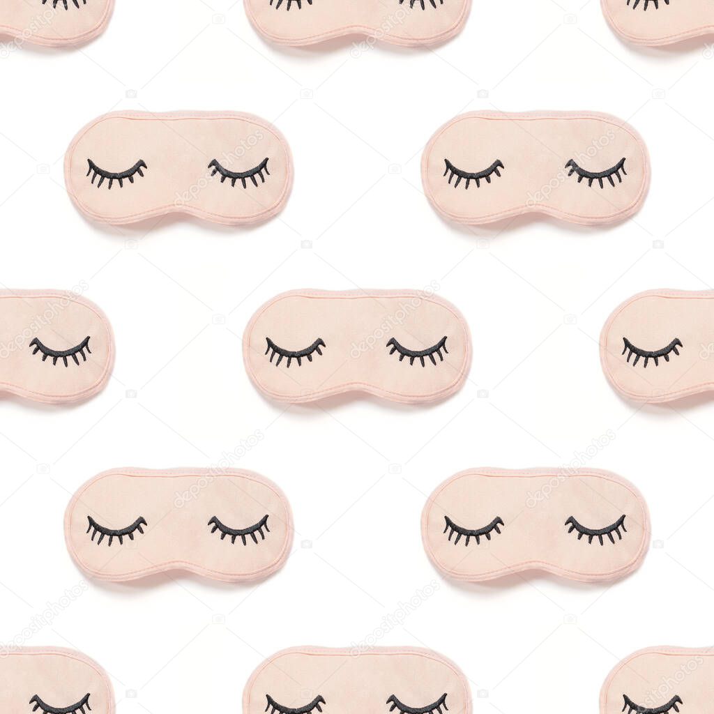 Seamless pattern from pink sleep mask with closed eyes embroidered on it with eyelashes isolated on white background. Photographic collage. Top view, flat lay. Accessories for girls and young women.