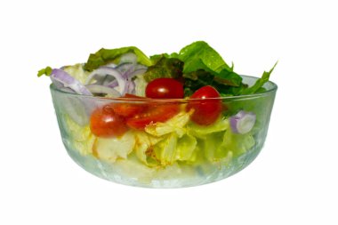 Bir grup organik sebze, kırmızı soğan, domates, yeşil yapraklar cam kasede karıştırılmış beyaz arka planda izole edilmiş, taze salata sosu