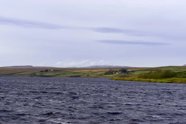 Landscape of water in reservoir against Green fields, dystone line and bans in the Yorkshire Dales