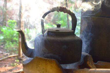 Mutfakta dumanlı eski alüminyum çaydanlık..