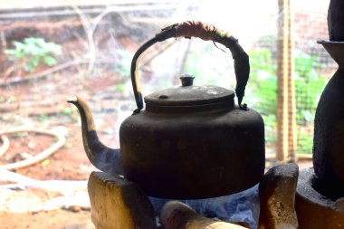 Mutfakta dumanlı eski alüminyum çaydanlık..