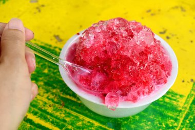 Sarı-yeşil masa üzerinde köpük bardakta tatlı buzlu dondurma. Yazın ünlü Tayland tatlıları.