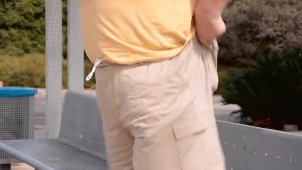 Un homme debout tire vers le haut en tombant pantalon beige — Video