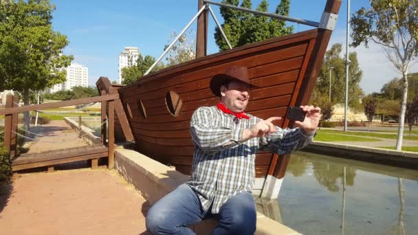 Cowboy feliz se divertindo e brincando com o telefone móvel — Vídeo de Stock