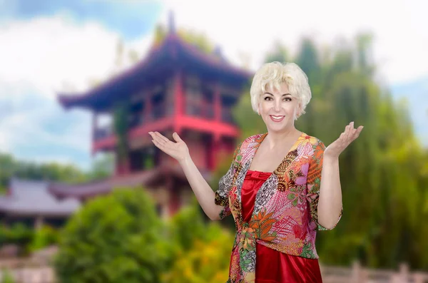 Donna in multi scrollata di spalle colorata in posa sulla pagoda asiatica — Foto Stock