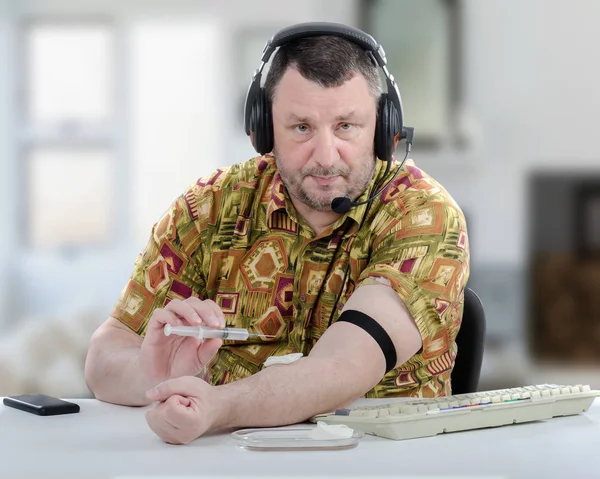 Man in aloha shirt is ready for self intravenous injection — Stock Photo, Image