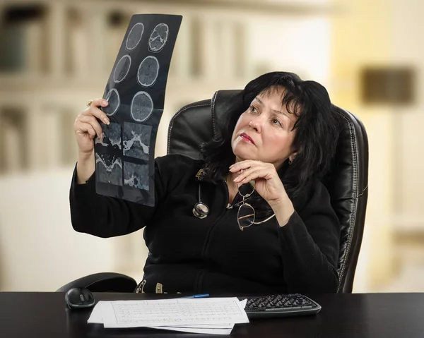 Selbstbewusster Arzt untersucht Gehirn-Röntgenbild — Stockfoto