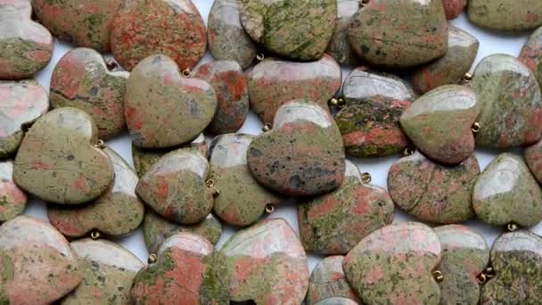 Small ring-shaped unakite hearts turn around — Stock Video