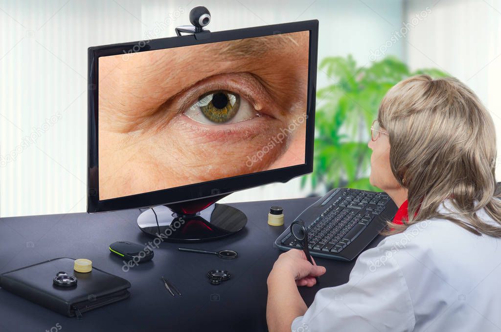 Telemedicine eye doctor observes eyelid cyst on computer