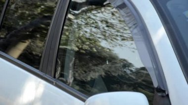 Sakallı adam yan araba penceresi bir ayna olarak bakıyor