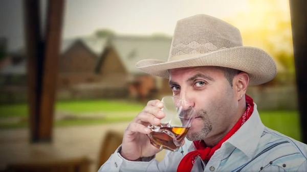 Cowboy njuter glas snyggt whiskey i utomhus bar — Stockfoto