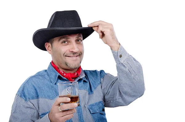 Cowboy tipping hat holds glass of neat whiskey — Stock Photo, Image