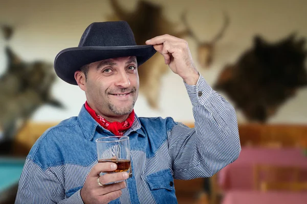 Freundlicher Cowboy im Jeanshemd prostet ordentlich Whiskey zu — Stockfoto