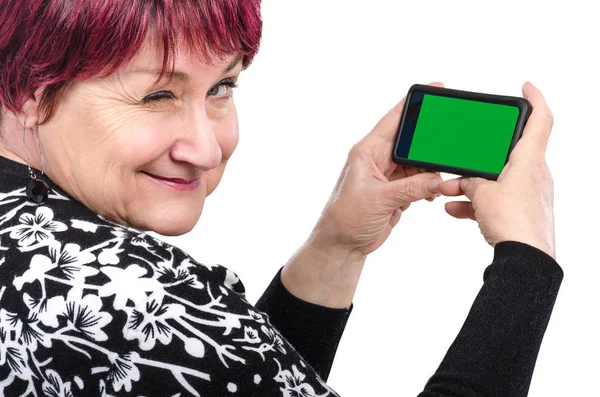Mobiltelefon tartó idősebb női kacsint a kamera — Stock Fotó