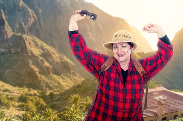 Animado mochilero mujer mayor posando en las montañas fondo —  Fotos de Stock