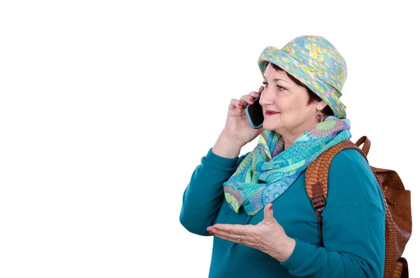 Backpacking older woman talking by cell phone — Stock Photo, Image