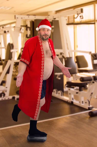 Fat Santa posando en la pierna izquierda en el gimnasio — Foto de Stock