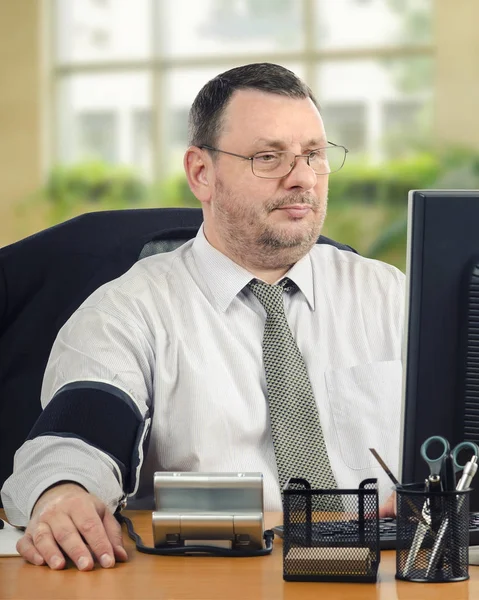 Manager telemonitoring blood pressure at workplace — Stock Photo, Image