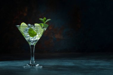 Siyah arka planda martini bardağında mojito kokteyli.