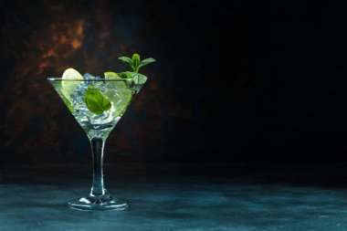 Siyah arka planda martini bardağında mojito kokteyli.